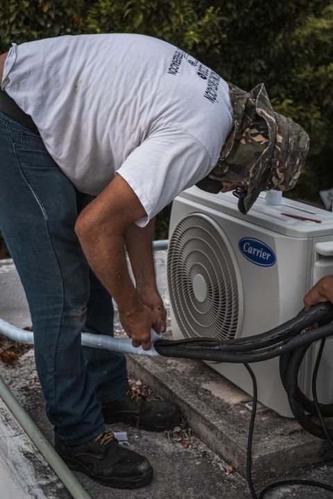 HVAC technician repairing a home air-conditioning unit